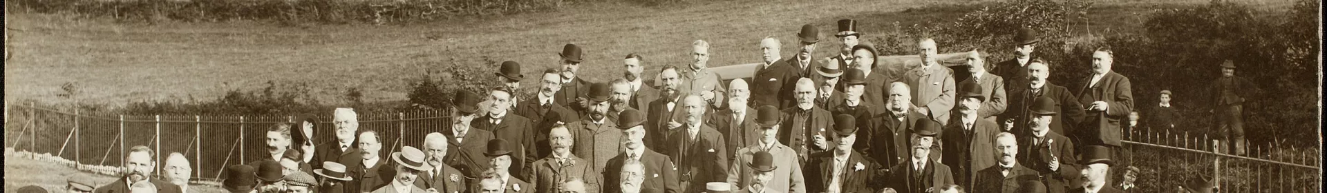 Photograph of a large group of civic dignitaries standing at the edge of a new reservoir 